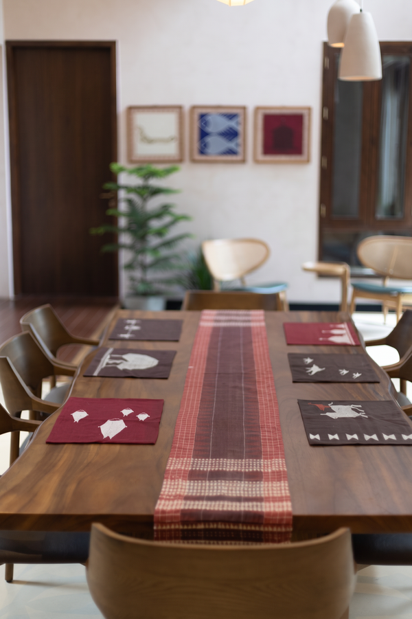 Kotpad placemats woven in Koraput, featuring motifs inspired by nature and everyday life of the Mirgan community. Made in cotton using natural dyes extracted from the roots of the aal tree.